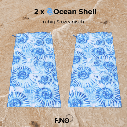 Zwei FiNo Mikrofaser-Handtücher im Ocean Shell Design auf Sand – saugstark, leicht und ideal für Strand & Reise